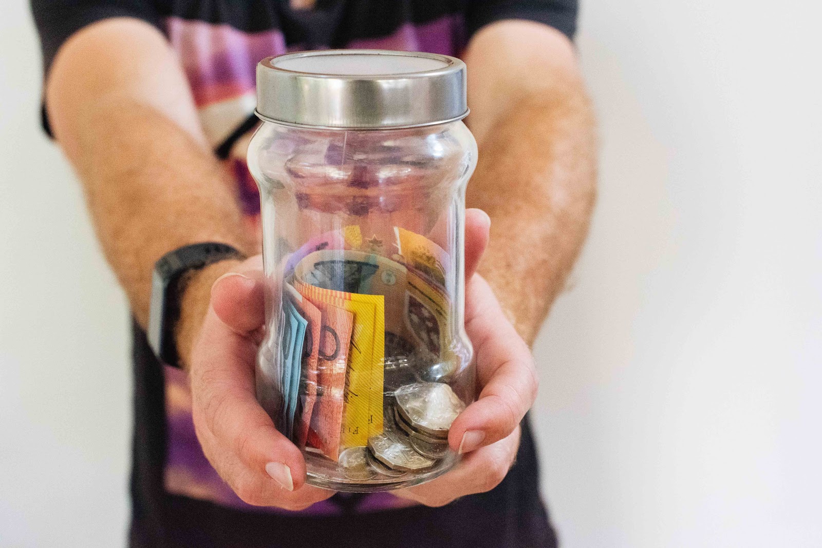 Man holding Jar Full of Australian Currency